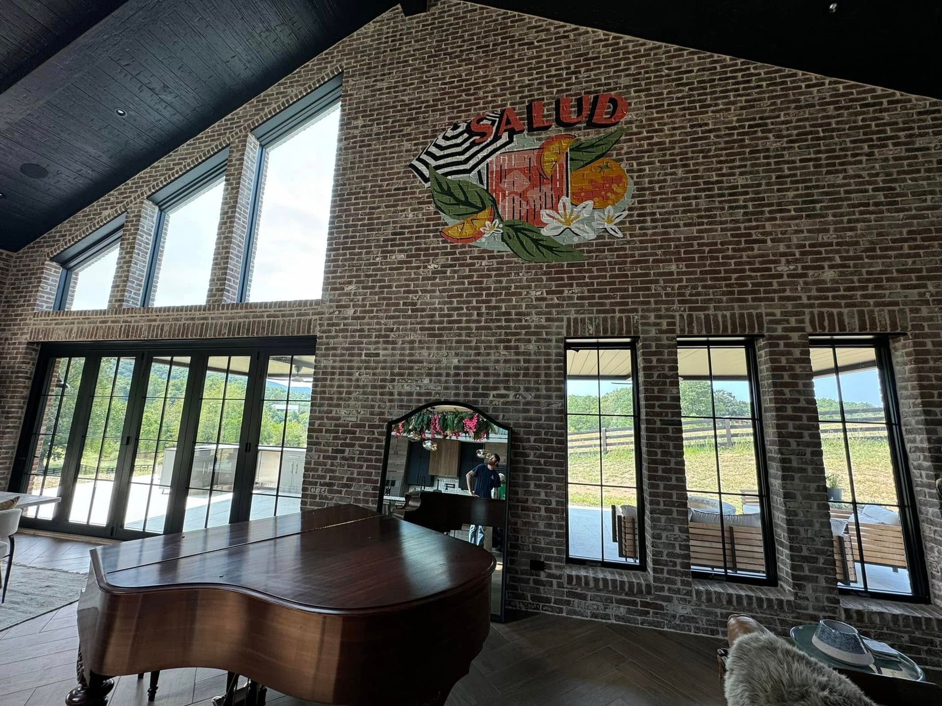 A living room with a piano and a brick wall
