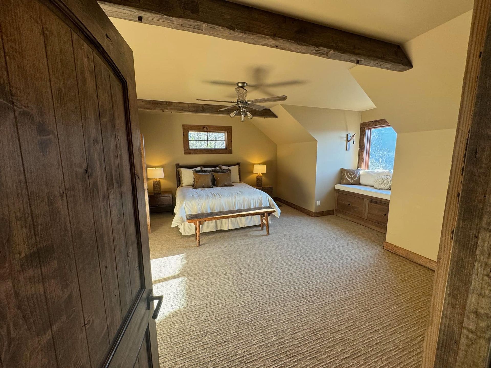 A bedroom with a king size bed and a window seat.