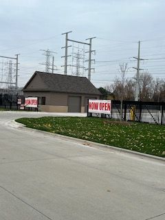 A building with a now open sign in front of it.