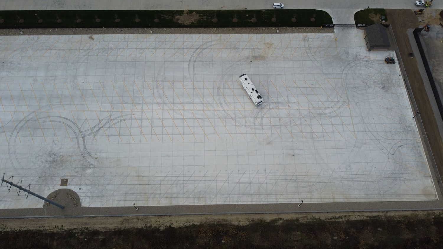 An aerial view of a parking lot with a white RV parked in the middle.