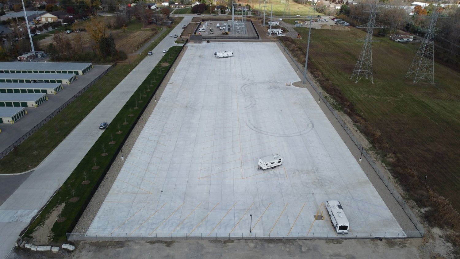 An aerial view of a large empty parking lot with a lot of cars parked in it.
