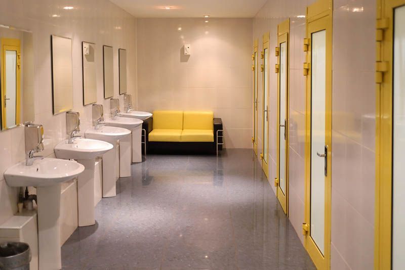 A restroom with sinks and a yellow couch