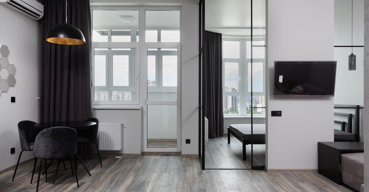 A living room with a dining table and chairs and a flat screen tv.