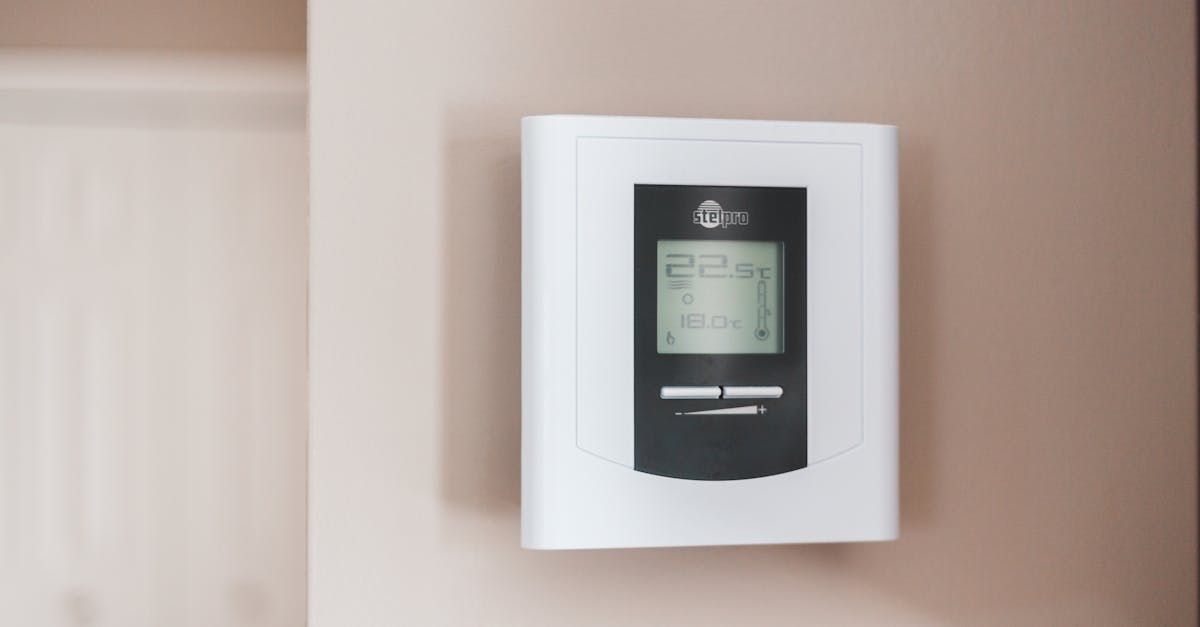 A digital thermostat is hanging on a wall.