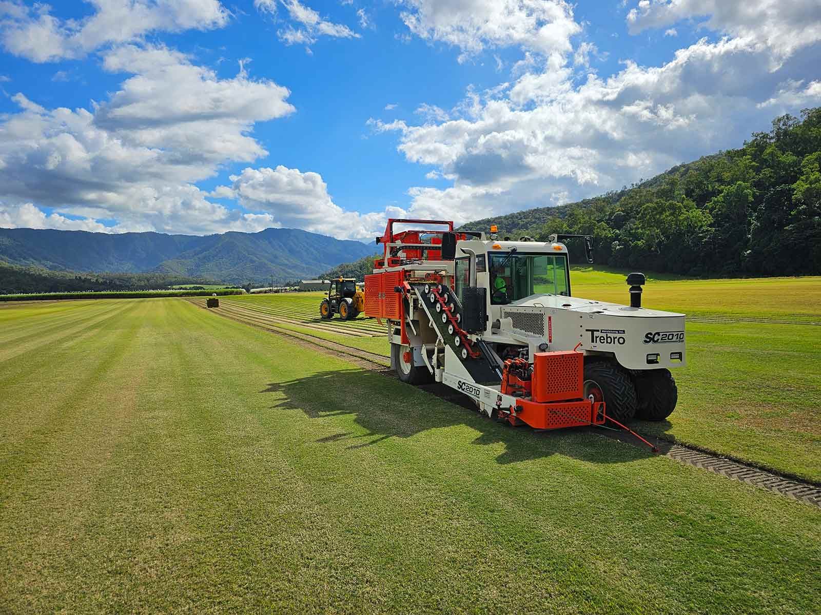 A Large Machine Is Sitting On Top Of A Lush Green Field — Tropical Lawns Pty Ltd In Little Mulgrave Qld