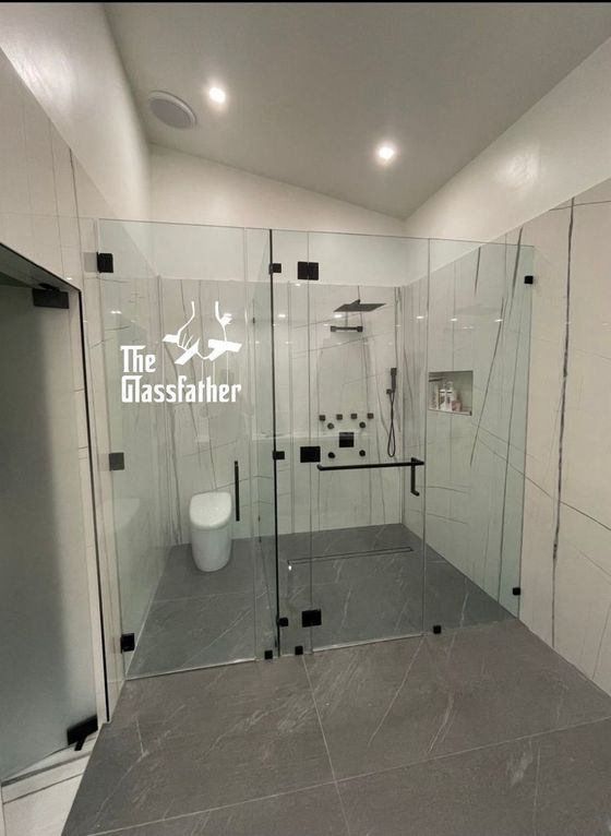 A bathroom with a glass shower door and a toilet.