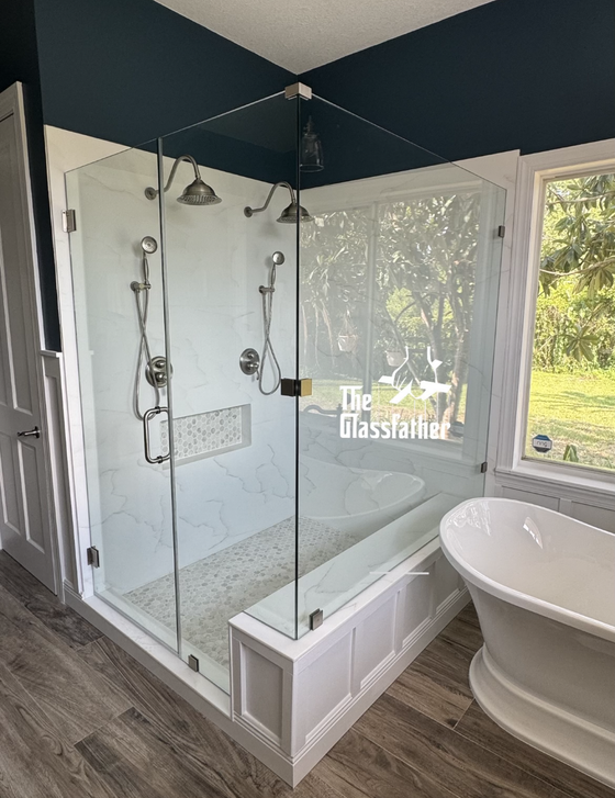 A bathroom with a tub and a shower with a glass door.