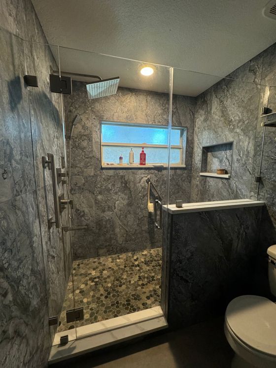 A bathroom with a walk in shower and a toilet.