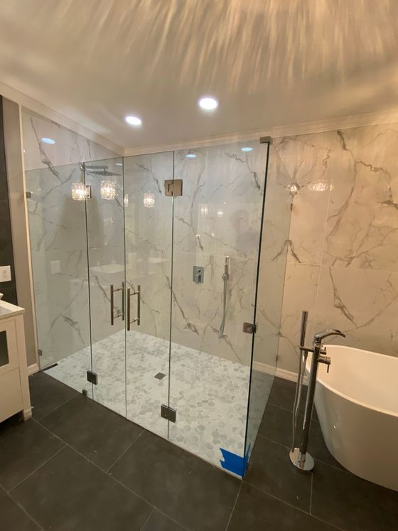 A bathroom with a walk in shower and a bathtub.