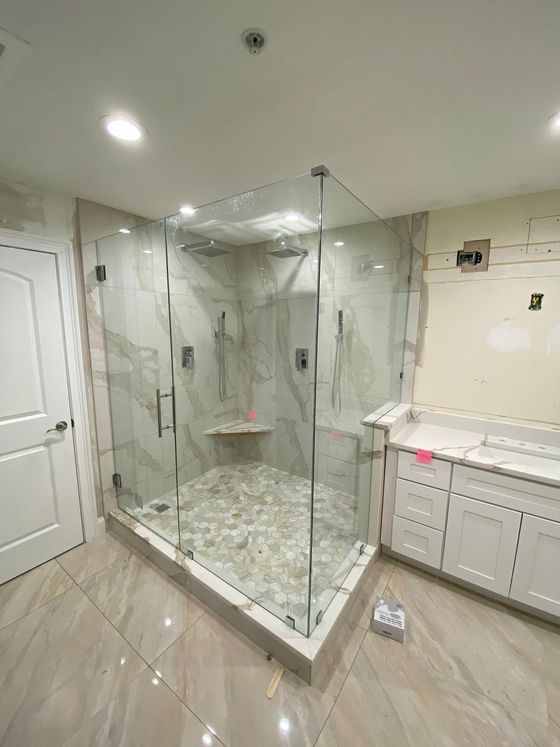 A bathroom with a walk in shower and a sink.