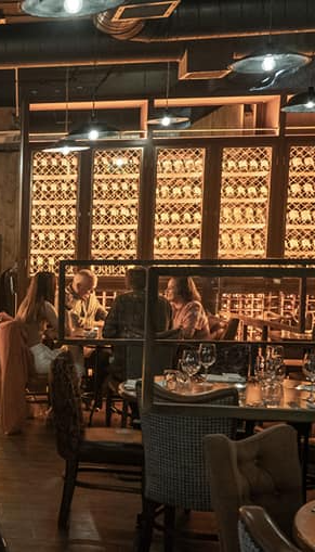 a group of people are sitting at tables in a restaurant .