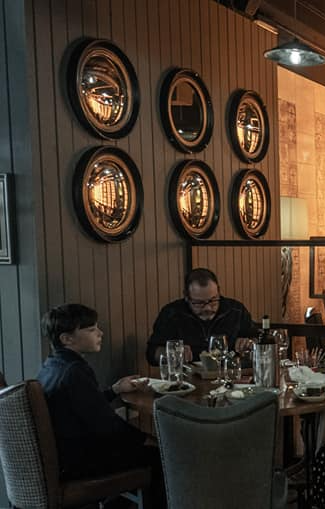 a man and a boy are sitting at a table in a restaurant .
