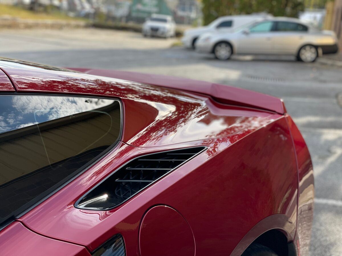 a red sports car is parked on the side of the road .