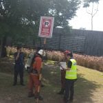 Firefighters and emergency personnel in a park setting with a 