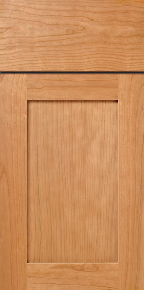 Close-up of a light-brown wooden cabinet door with a recessed center panel.