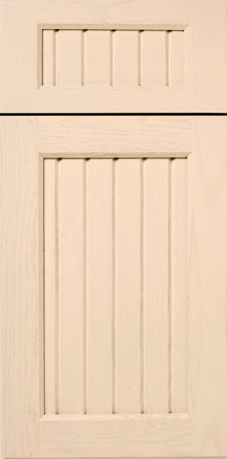 Cream-colored kitchen cabinet with a panel of vertical slats within a framed rectangle and small upper panel.