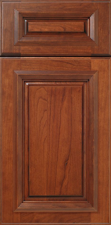 Close-up of a wooden cabinet door with recessed panel and raised trim in a warm brown color.