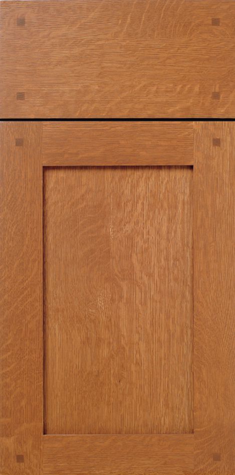 Close-up of a wooden cabinet door with a light brown finish and small square decorative details.