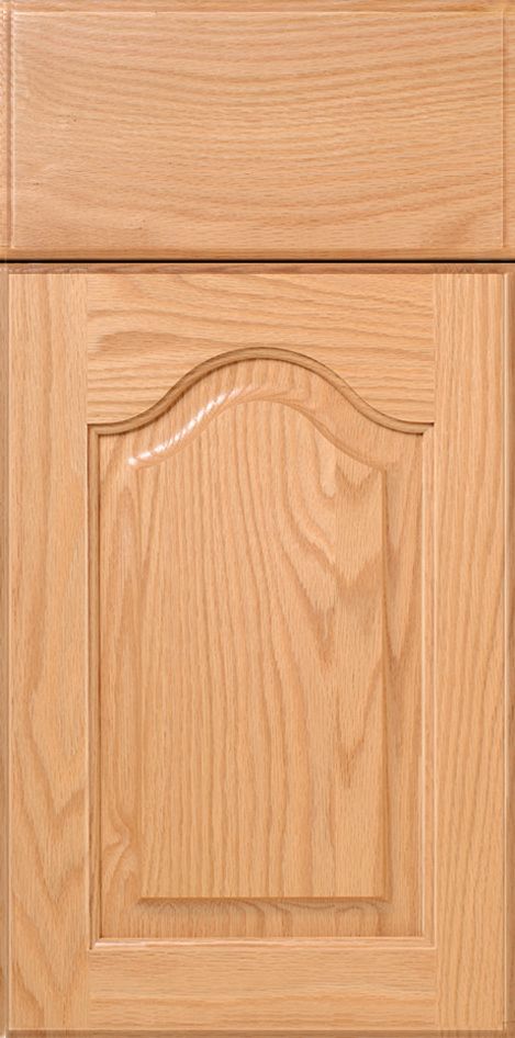 Light oak kitchen cabinet with raised panel and arched top detail.
