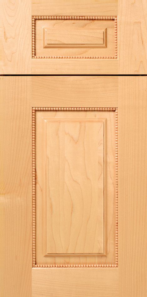 Light wood cabinet door with raised panel design and detailed trim.
