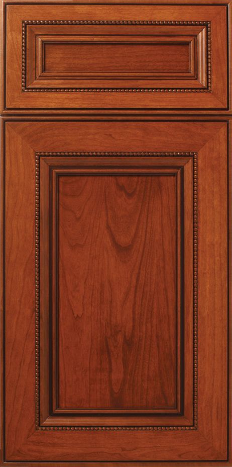 Cherry-stained kitchen cabinet door with detailed trim.