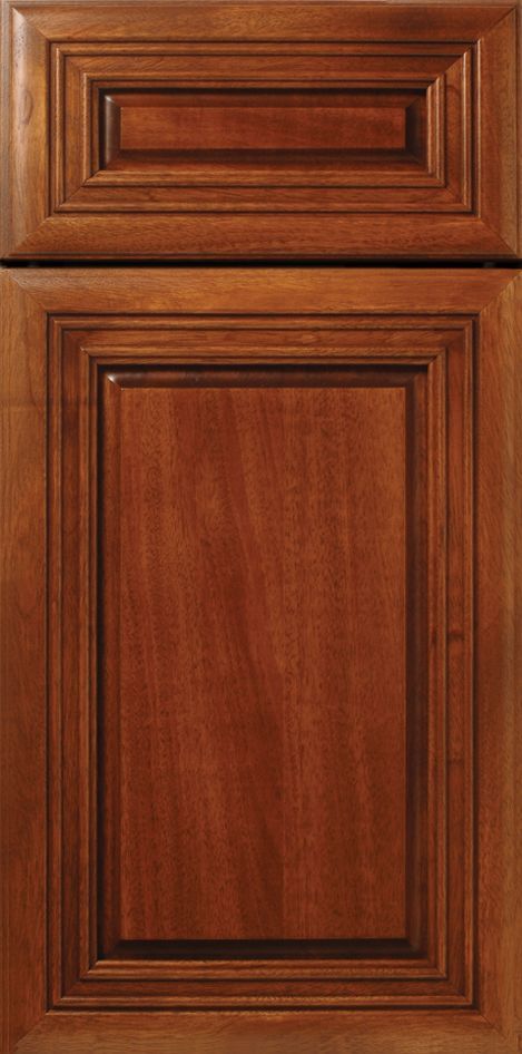 Wooden kitchen cabinet door with raised panel and detailed trim in a warm brown color.