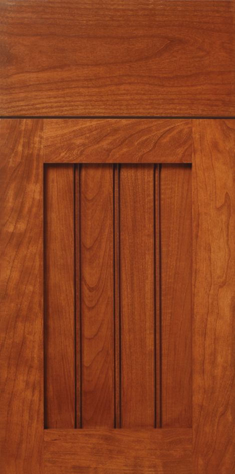 Wooden cabinet door with a raised panel and vertical grooved details.