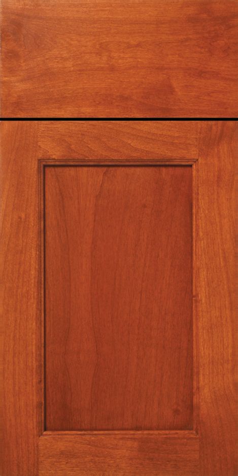 Close-up of a stained wooden cabinet door with a recessed panel, warm brown tone.
