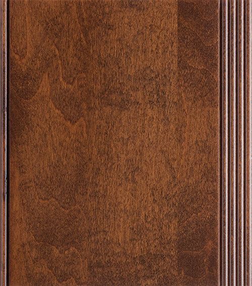 Close-up of a stained wood cabinet door with a brown finish and vertical grooves on the right side.