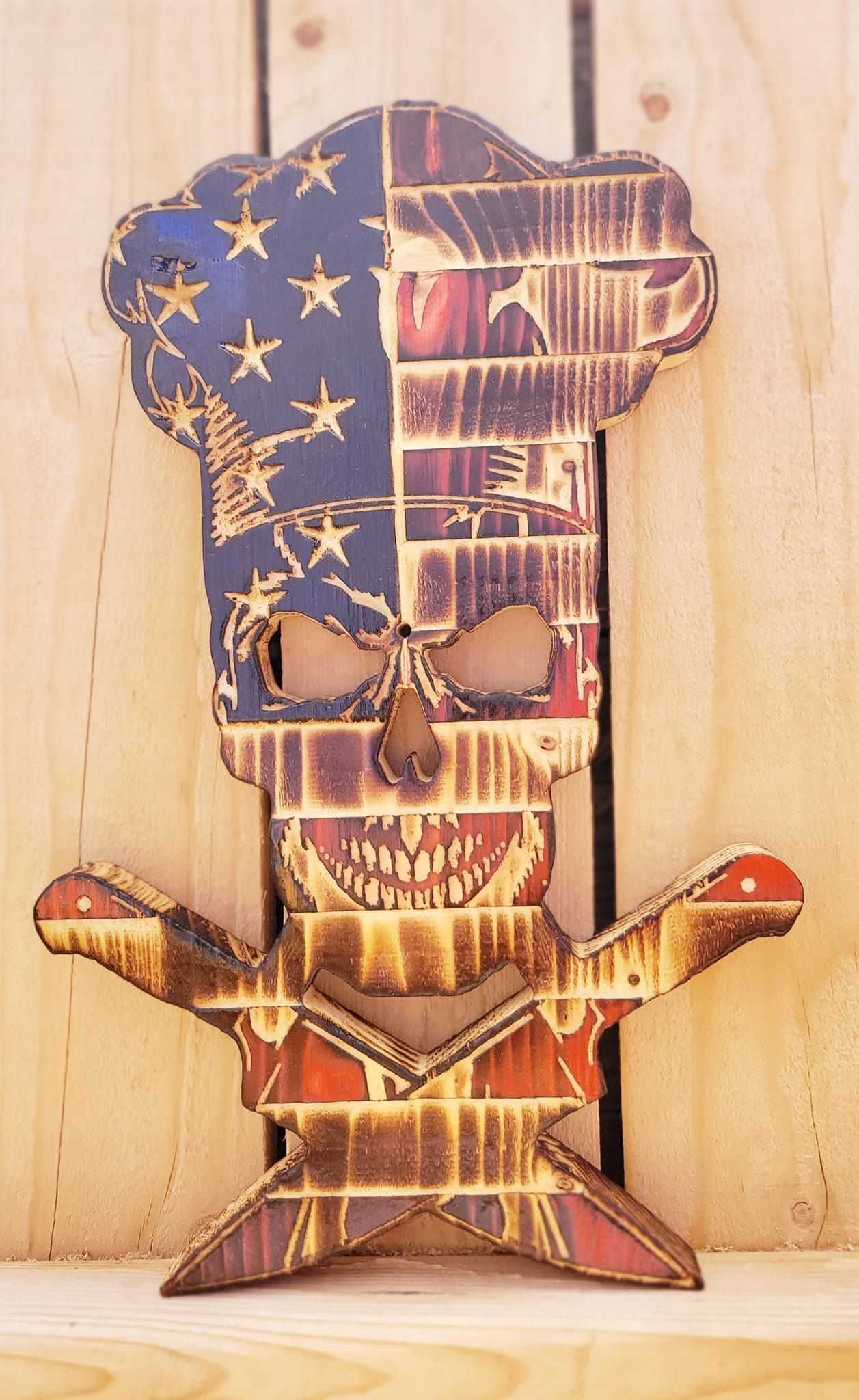 Wooden chef skull, USA flag themed, with arms spread.