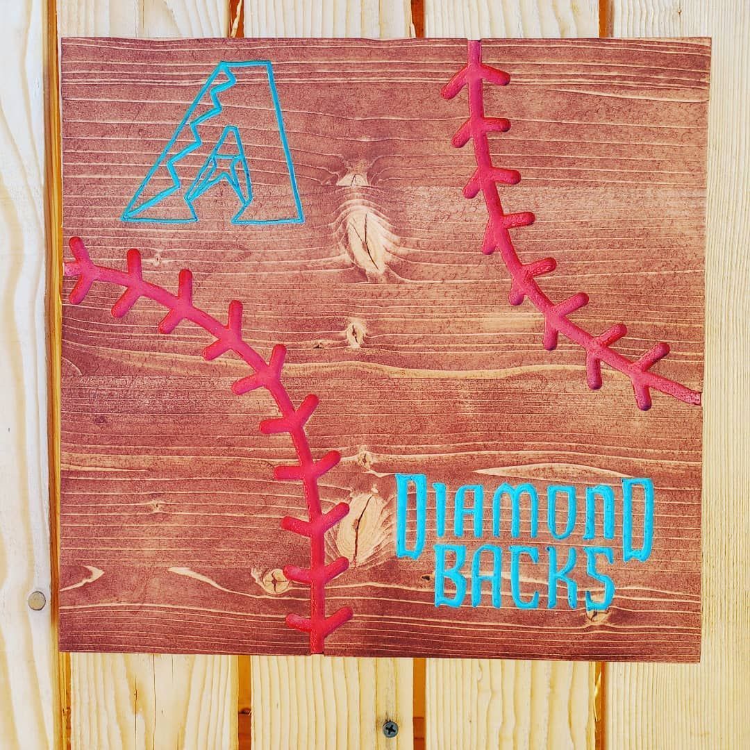 Wooden sign with Arizona Diamondbacks logo and baseball stitching in pink and teal.