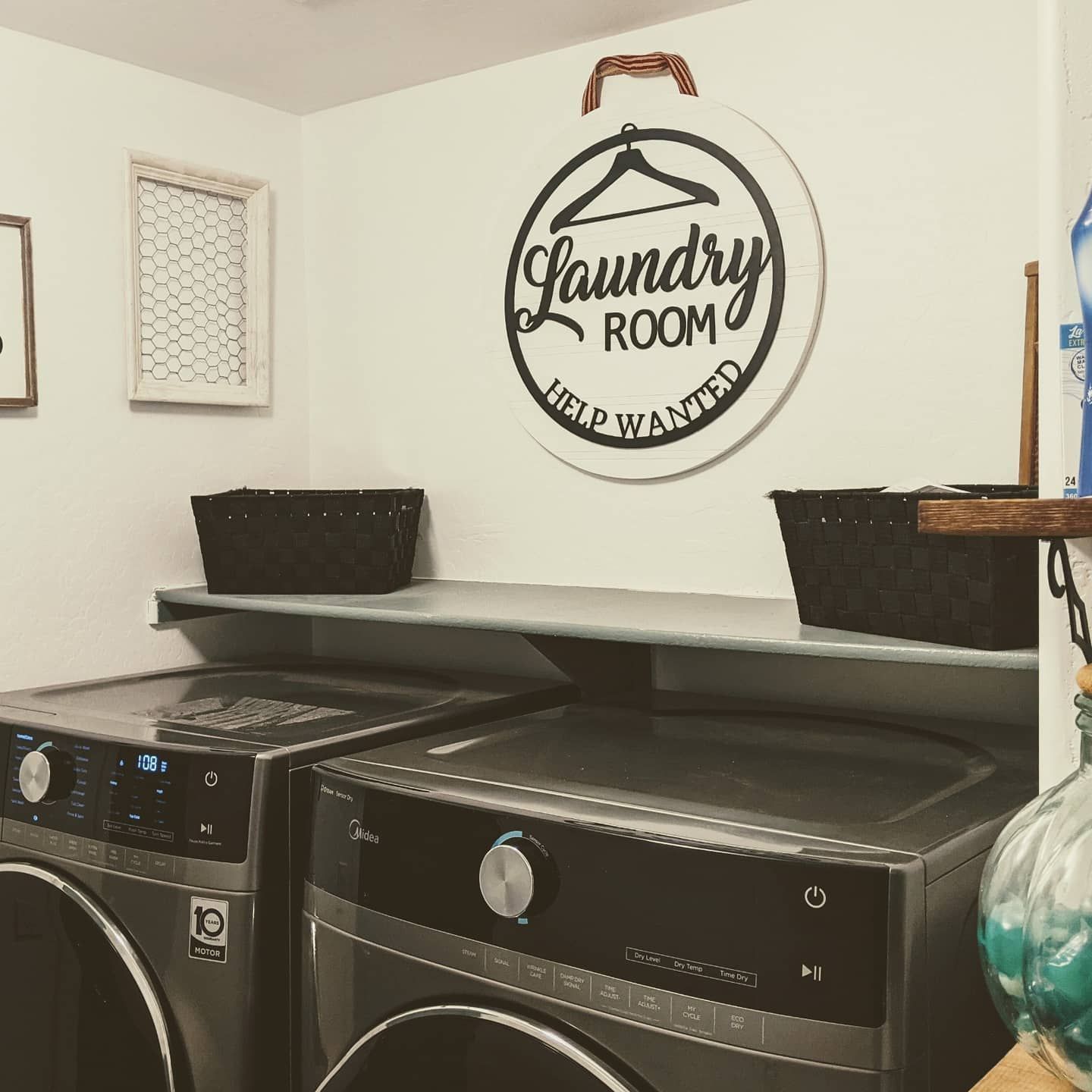 Laundry room with washer, dryer, shelves, baskets, and a