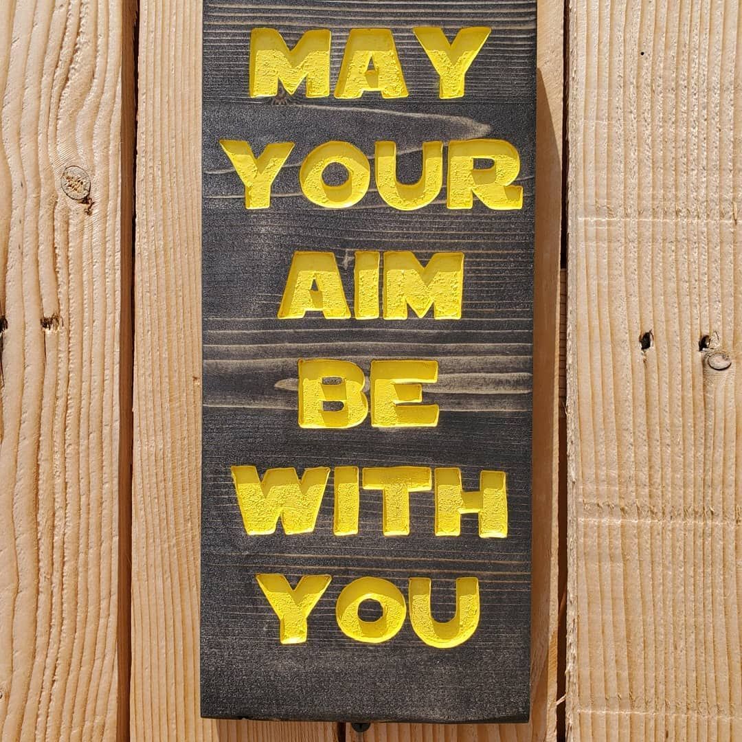 Wooden sign with yellow lettering: