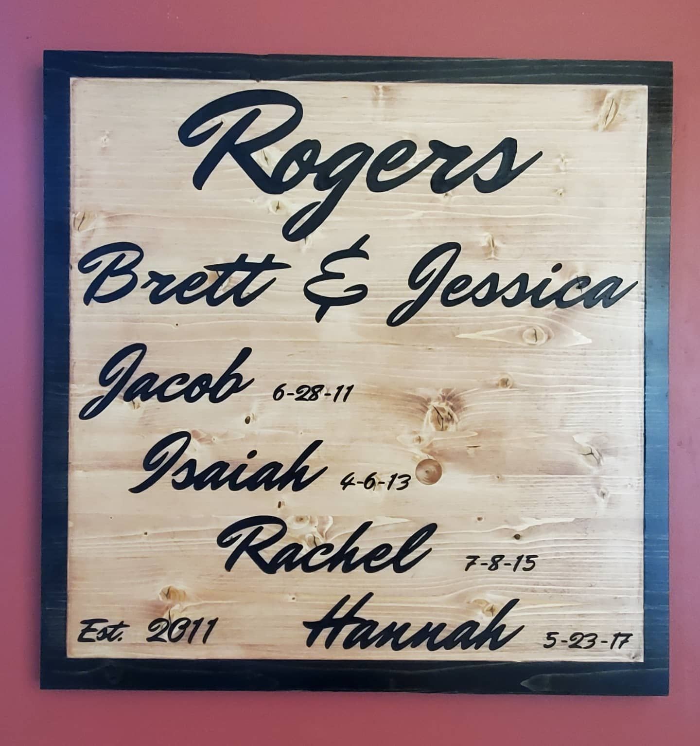 Wooden family name sign with black lettering: