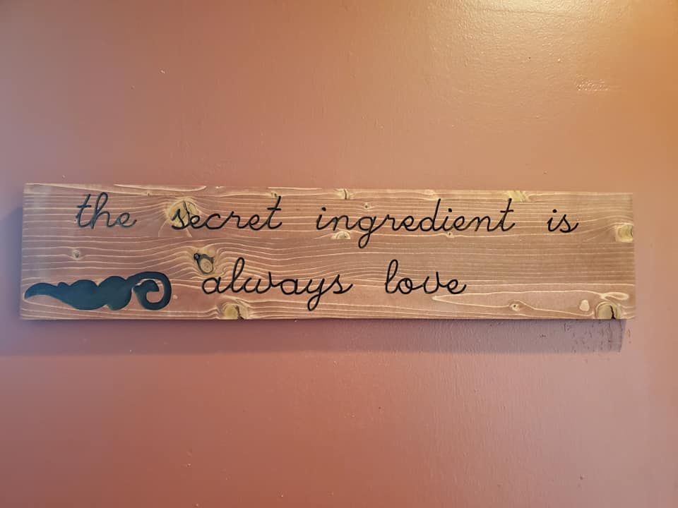 Wooden sign with cursive text: