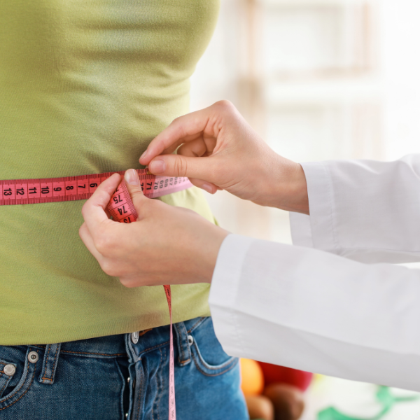 Sandstone Therapeutic Massage / A woman's waist is being measured