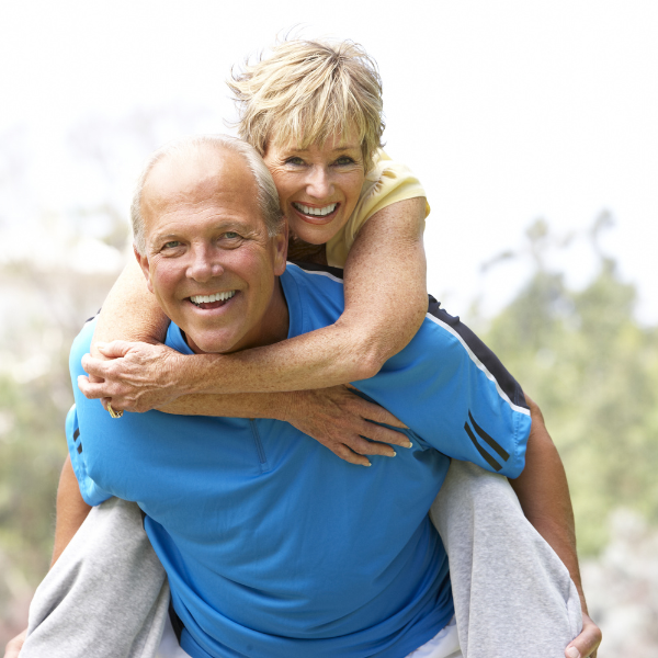 Sandstone Therapeutic Massage / Health man and woman where the man is carrying the woman on his back. 