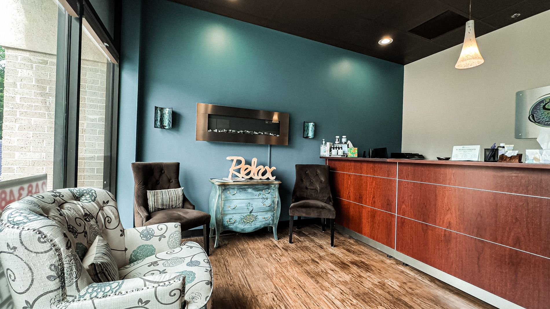 A waiting room with chairs and a wooden counter at Sandstone Therapeutic Massage.