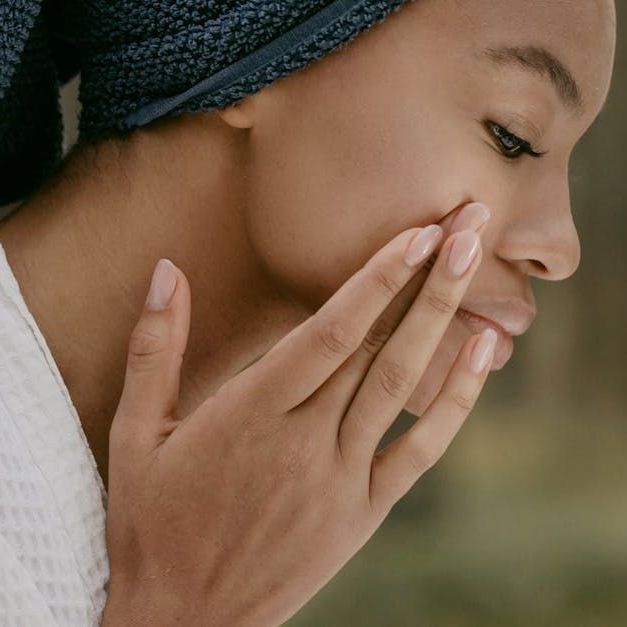 Sandstone Therapeutic Massage / A woman touching her face.