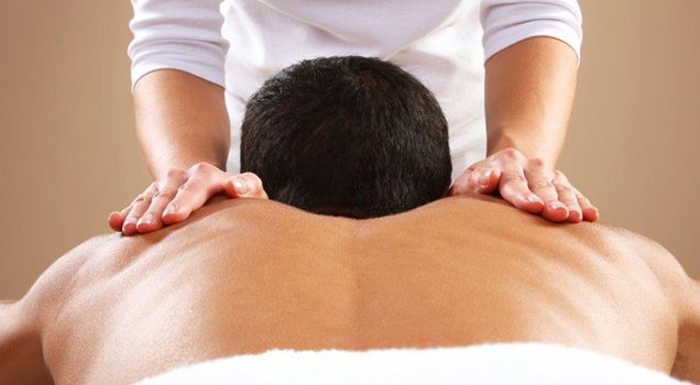 A man is getting a massage from a woman in a spa.