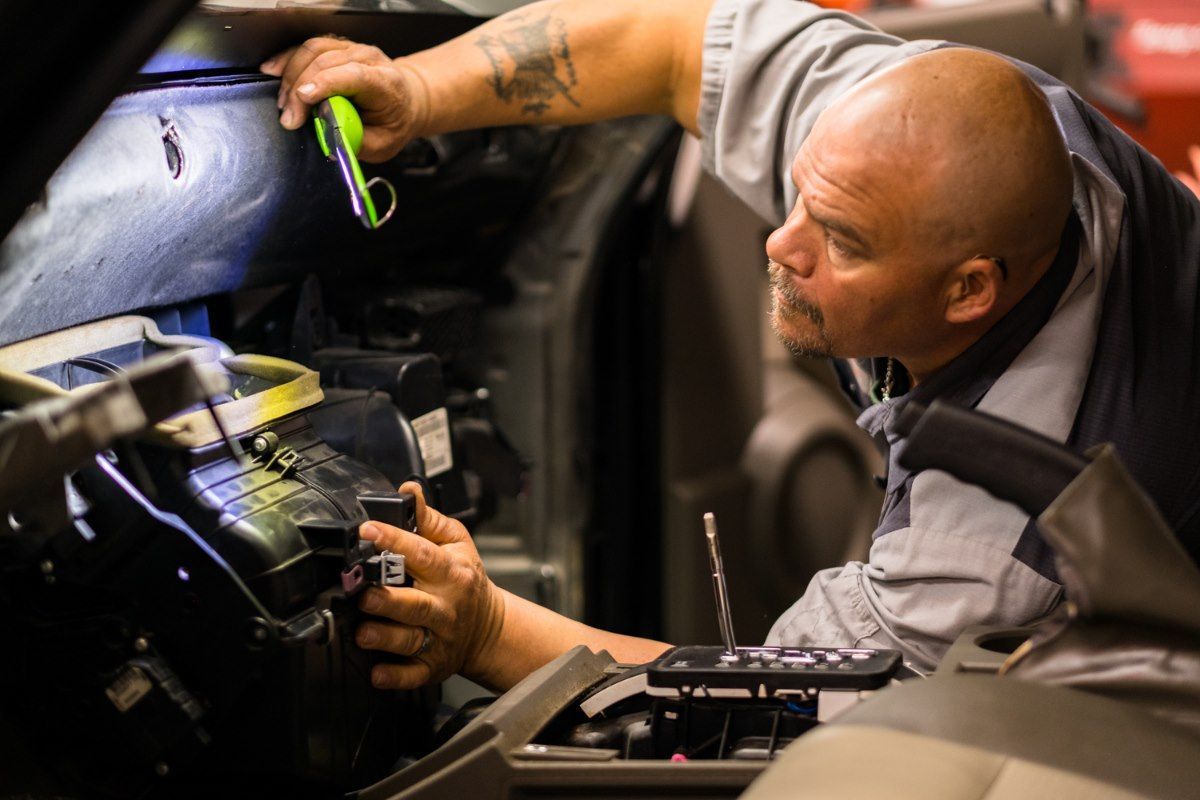 a man with a tattoo on his arm is working on a car