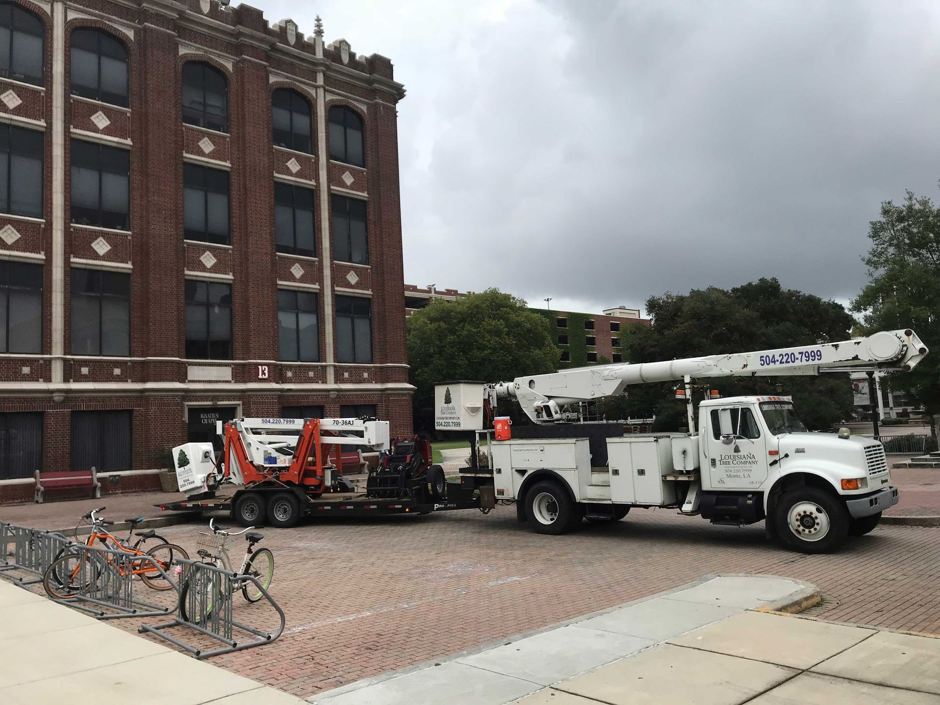 A white truck is parked in front of a brick building