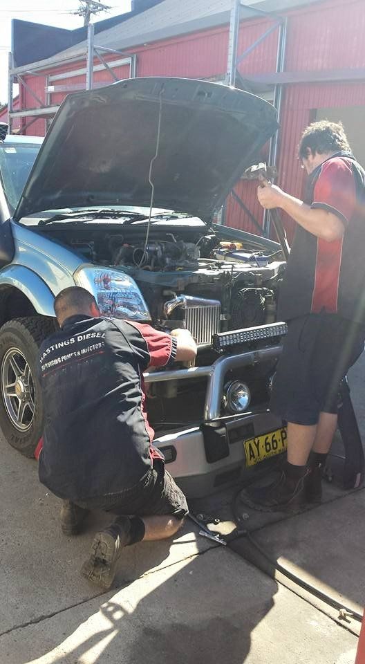 Two Men Are Working On A Car With The Hood Open — Hastings Diesel Service In Wauchope, NSW
