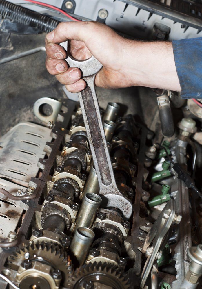 A Person Is Working On A Car Engine With A Wrench — Hastings Diesel Service In Wauchope, NSW