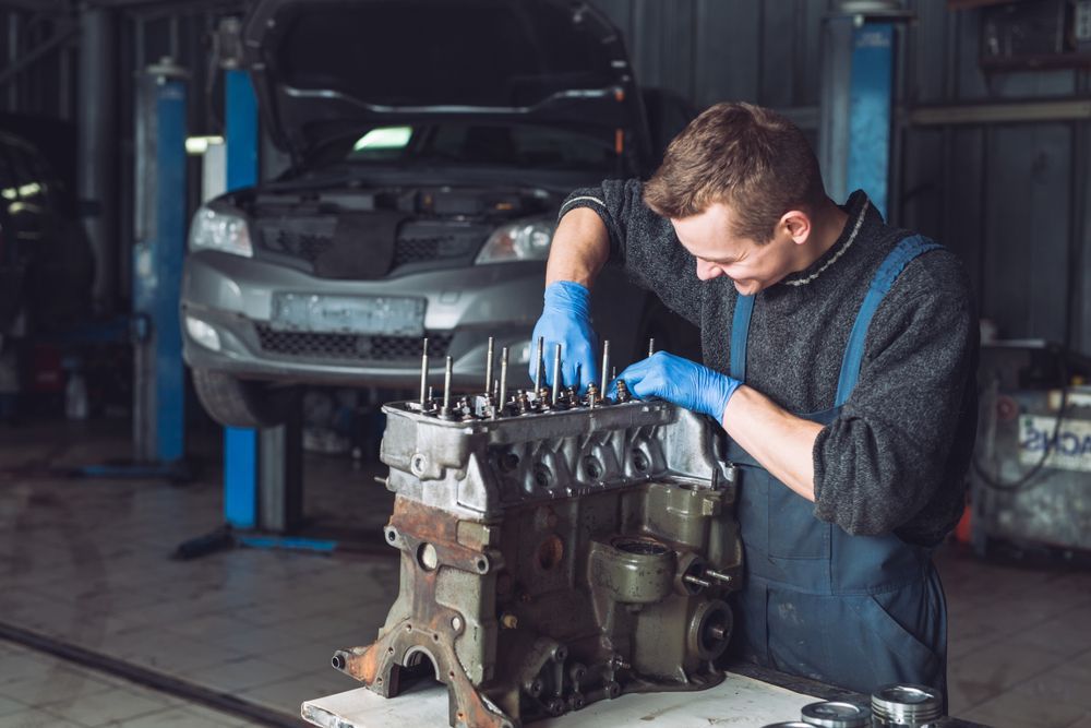 A Man Is Working On A Car Engine In A Garage — Hastings Diesel Service In Wauchope, NSW