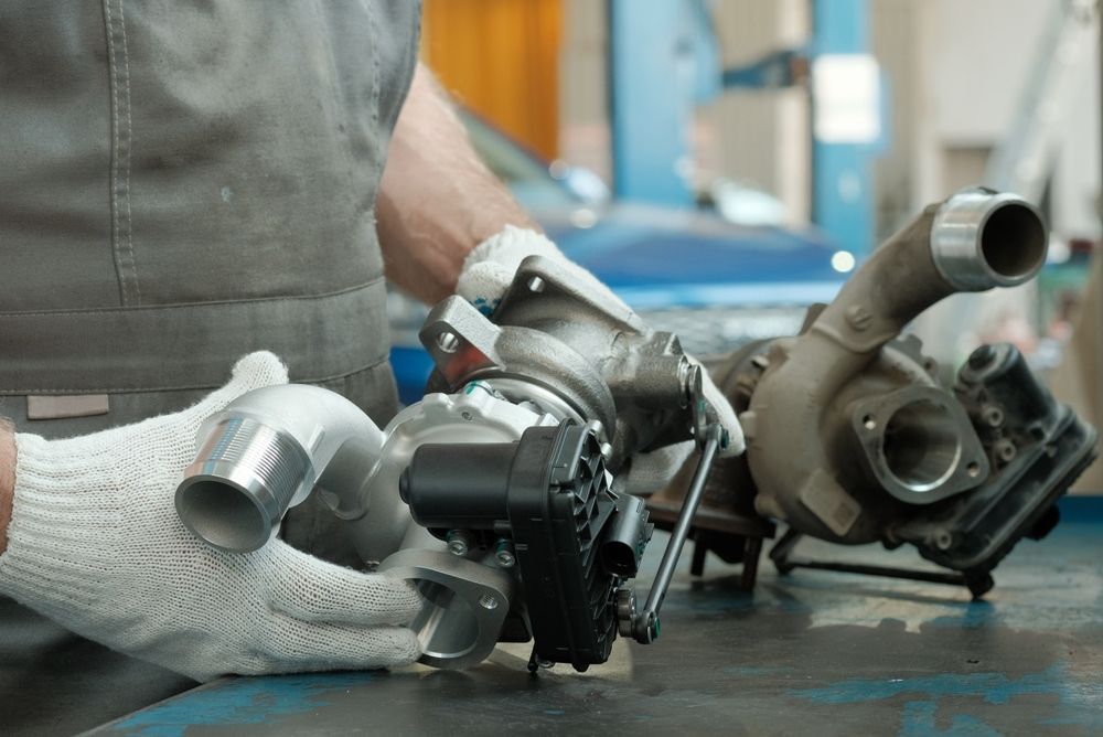 A Man Is Working On A Turbocharger In A Garage — Hastings Diesel Service In Wauchope, NSW