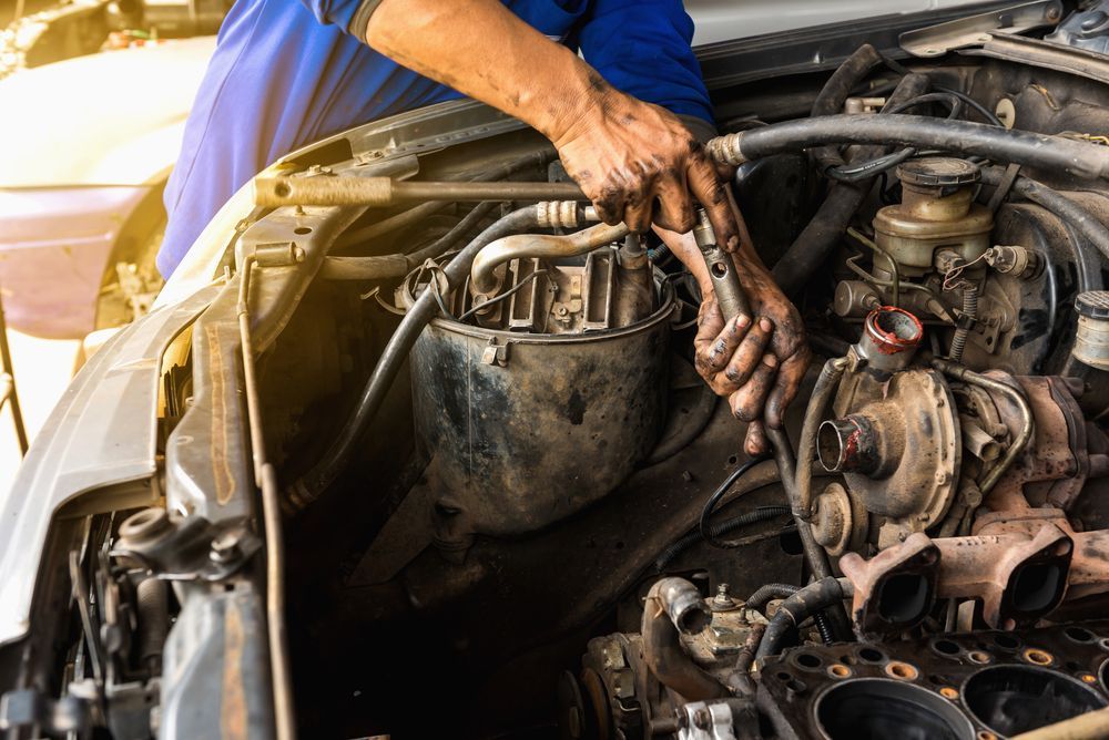 A Man Is Working On A Car Engine With A Wrench — Hastings Diesel Service In Laurieton, NSW