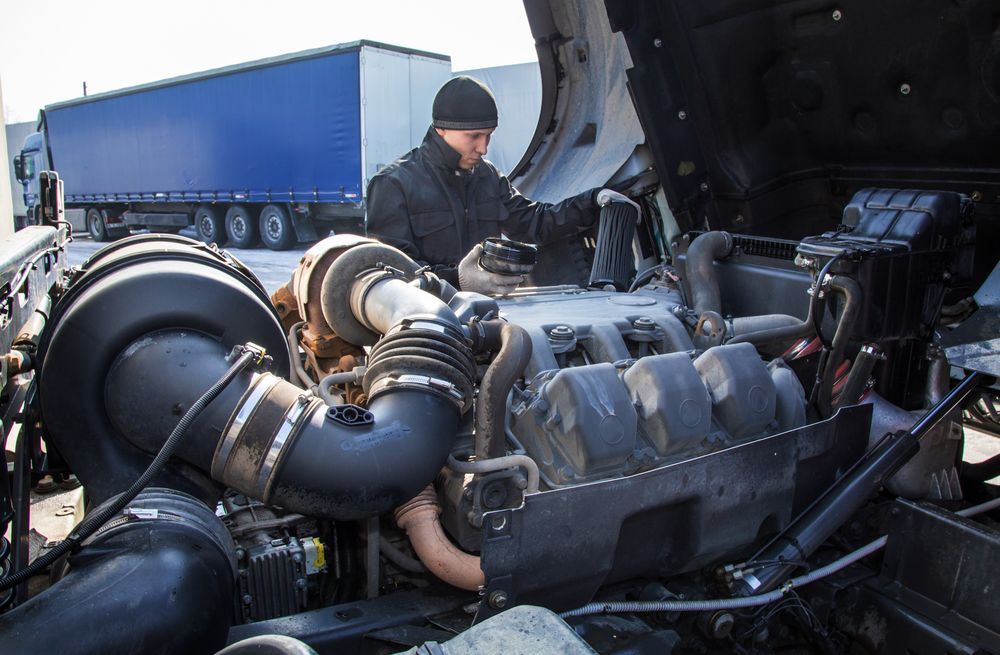 A Man Is Working On The Engine Of A Semi Truck — Hastings Diesel Service In Wauchope, NSW