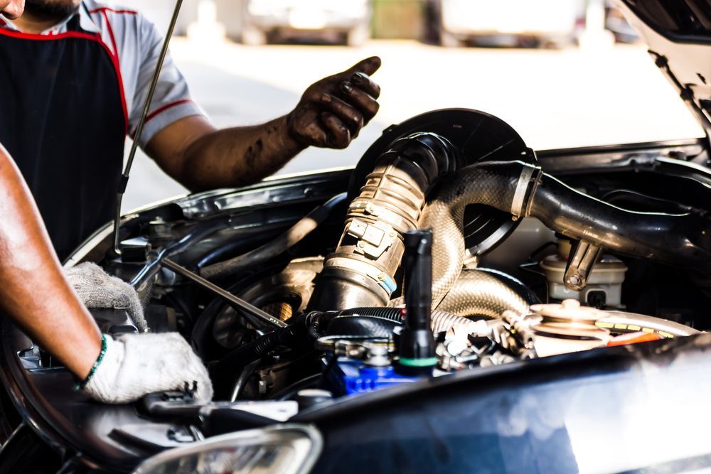 A Man Is Working On The Engine Of A Car — Hastings Diesel Service In Laurieton, NSW