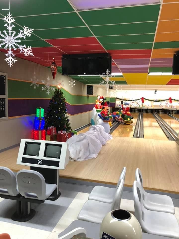 A bowling alley decorated for christmas with a christmas tree